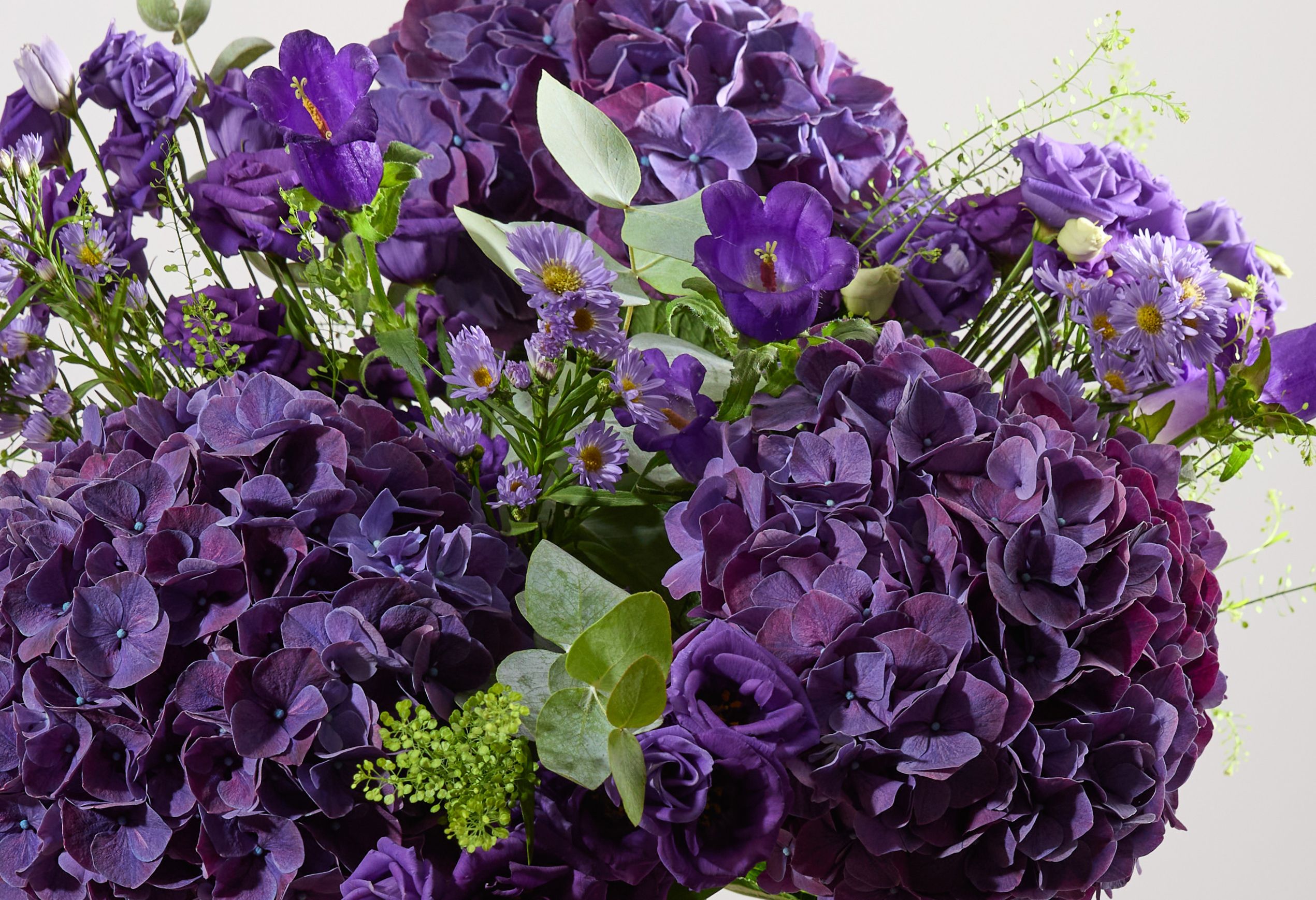 A close crop of our Purple Reign bouquet, featuring purple hydrangeas, asters, lisianthus and campanula